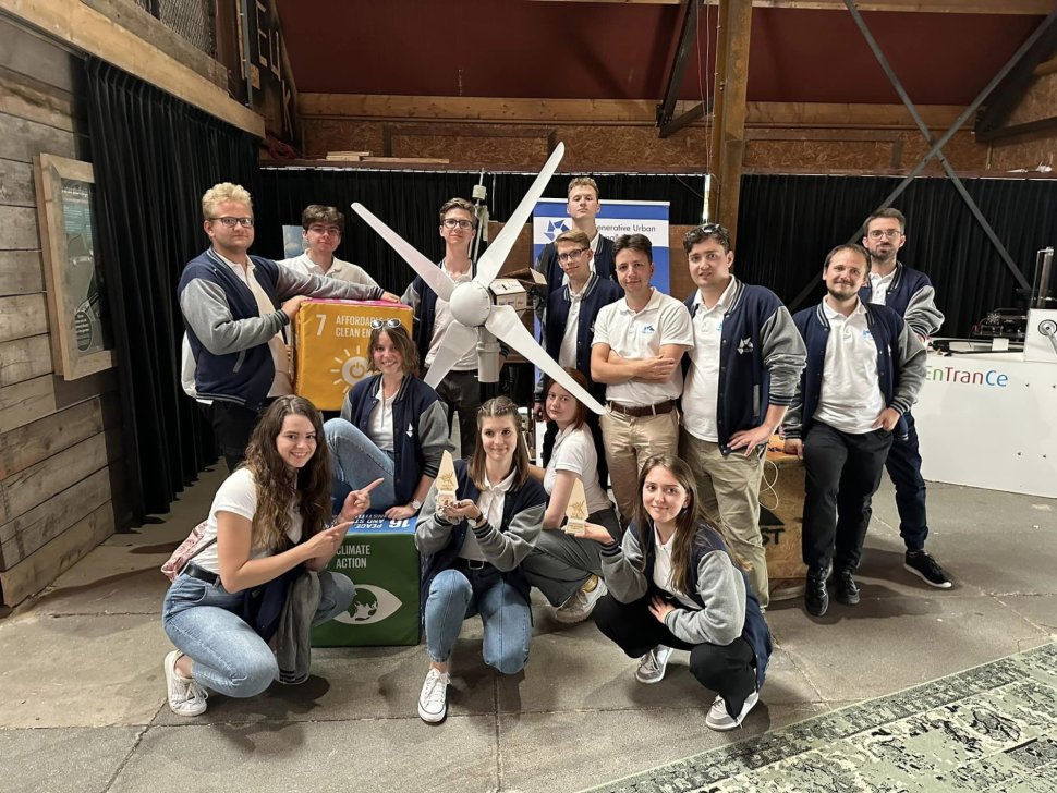 A group of students standing near a wind turbine