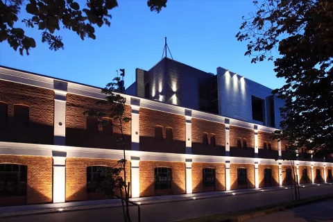 The illuminated building A19 of the Faculty of Mechanical Engineering of Lodz University of Technology from Stefanowskiego Street. Behind the building is the Factory of 21st Century Engineers.