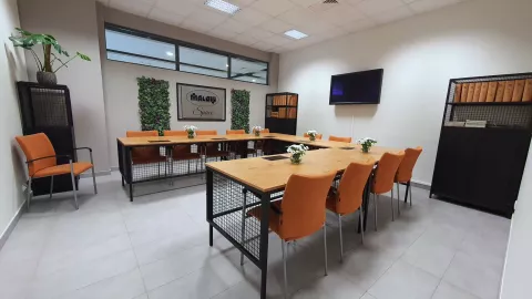 Seminar room at the Institute of Materials Science with chairs, tables, green accent of vegetation on the walls with the inscription MALOW Space on the wall