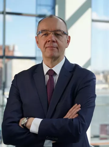 Professor Tomasz Kubiak standing in front of a window wall 